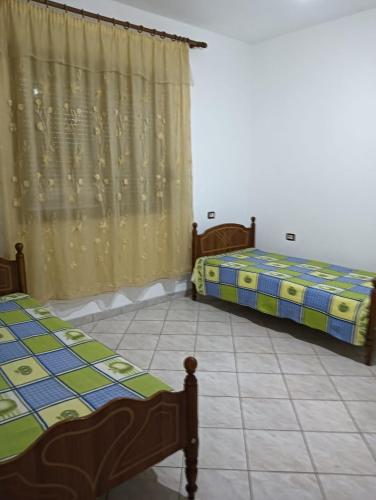 two beds sitting in a room with a curtain at Private Home Durres in Durrës