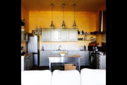 a kitchen with white cabinets and a table in it at Villa Paradiso,stunning views ac heated pool in Coreglia Antelminelli