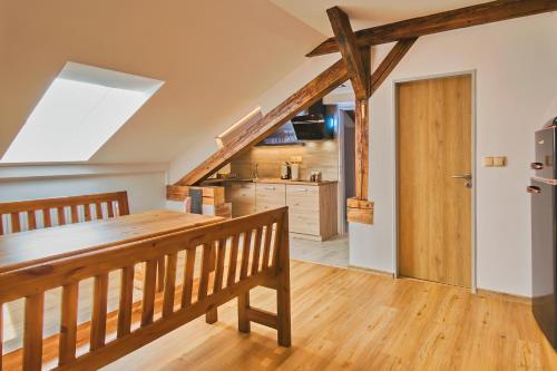 a kitchen with a wooden table and a wooden staircase at Penzion Bejby Turnov in Turnov