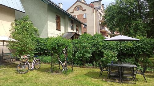 una mesa con sombrilla y una bicicleta en un patio en Willa Retro Hostel en Cracovia