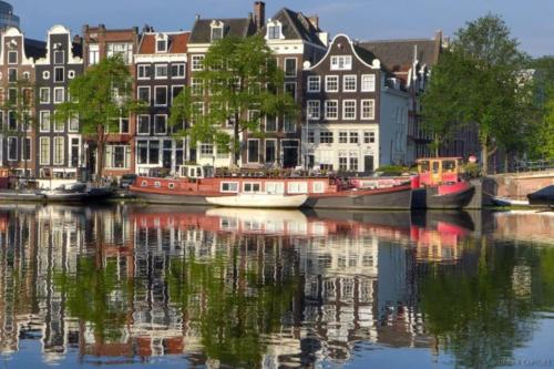 um grupo de casas e barcos num rio em Trendy apartment garden Amsterdam center em Amsterdã