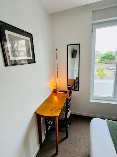 a desk in a room with a bed and a window at Le Clos Normand in Saint-Aubin-sur-Mer