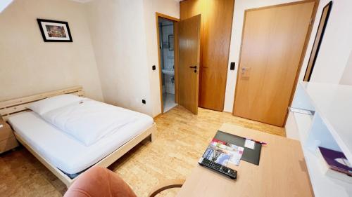 聖戈阿爾的住宿－Hotel zur Loreley - Garni，小房间设有一张床和一张桌子