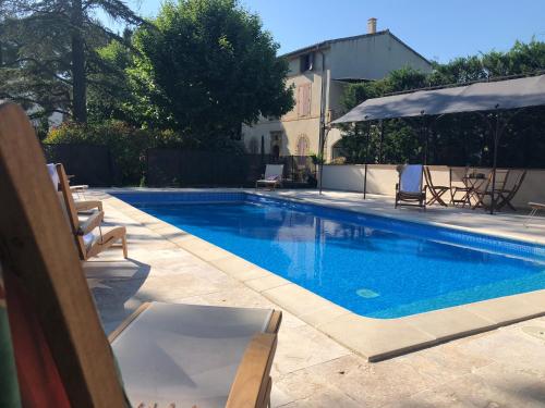 une piscine avec des chaises et un parasol dans l'établissement Villa Les Cedres, à Aix-en-Provence