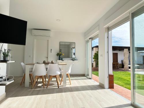 una cucina e una sala da pranzo con tavolo e sedie di Villa Luna Novo Santi Petri a Chiclana de la Frontera