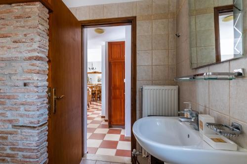 a bathroom with a sink and a brick wall at DROSIA HOME in Skopelos Town