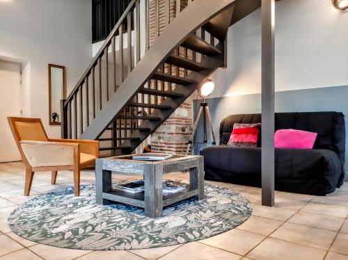 a living room with a couch and a table at Gîte Mara des Bois - Domaine du Pi geonnier de Saint-Vincent in Bourran