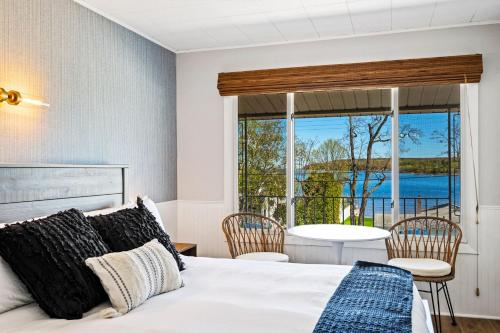 a bedroom with a bed and a view of the ocean at Fresh Coast Motel in Fish Creek