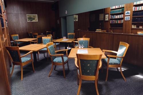 a row of tables and chairs in a library at Perkuno Namai Park Hotel in Kaunas