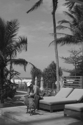 a man sitting on a bench with a dog next to him at Harding Boutique Hotel in Ahangama