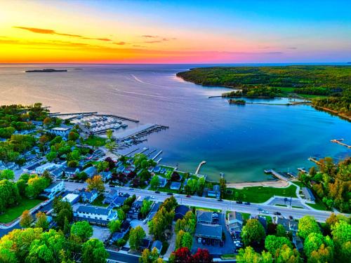 an aerial view of a town on the water at sunset at Fresh Coast Motel in Fish Creek
