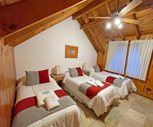 two beds in a room with wooden ceilings at Apart Hotel Orilla Mansa by Visionnaire in San Martín de los Andes