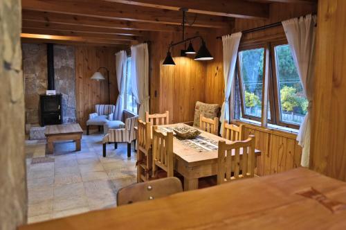 una sala da pranzo con tavolo e sedie di Apart Hotel Orilla Mansa by Visionnaire a San Martín de los Andes
