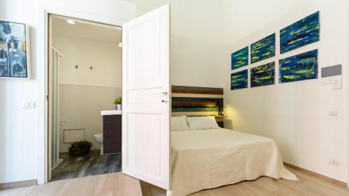 a white bedroom with a bed and a mirror at Donna Fortuna in Catania