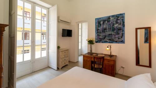 a bedroom with a bed and a desk and a window at Donna Fortuna in Catania
