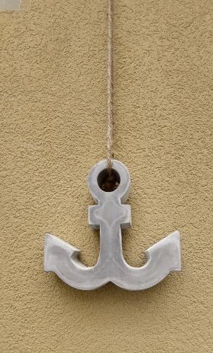 a metal cross hanging on a wall at Confortevole Bilocale Giardino Doppio Parcheggio in Punta Ala