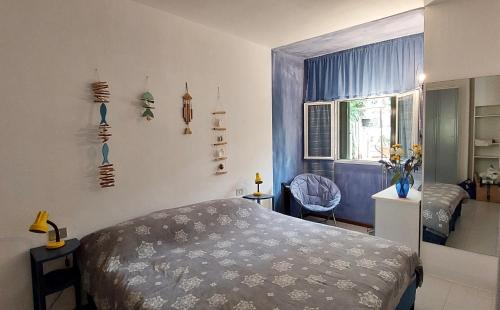 a bedroom with a bed and a room with a window at Confortevole Bilocale Giardino Doppio Parcheggio in Punta Ala