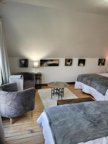 a living room with two beds and a table at Le petit Manoir Spa et Vue sur rivière St Maurice in Grandes-Piles