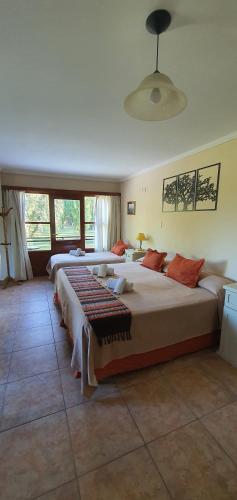 a bedroom with two beds and a large window at Hotel Risco Plateado Room & Suite in Malargüe
