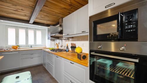 a kitchen with white cabinets and a stove top oven at Donna Fortuna in Catania