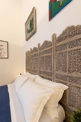 a bed with a wooden headboard in a room at Donna Fortuna in Catania