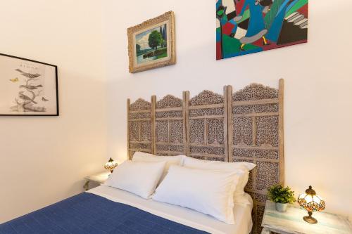 a bedroom with a bed with a wooden headboard at Donna Fortuna in Catania