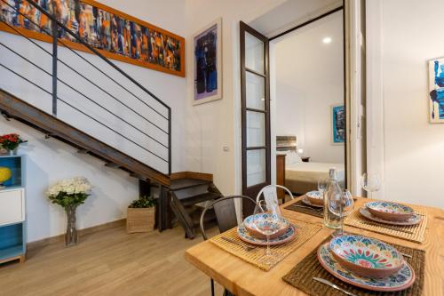 a dining room with a table and a staircase at Donna Fortuna in Catania
