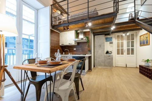 an industrial kitchen with a wooden table and chairs at Donna Fortuna in Catania