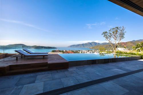 a pool with a bench and a view of the ocean at Venity Villa Nha Trang in Nha Trang