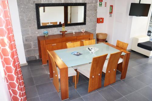 een eetkamer met een tafel en stoelen en een spiegel bij Casa Bela Vista in Geres