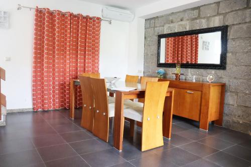 a dining room with a wooden table and chairs at Casa Bela Vista by Gerês Casas in Geres