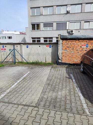 a car parked in a parking lot next to a building at Apartman Kuzmanyho Žilina centrum in Žilina