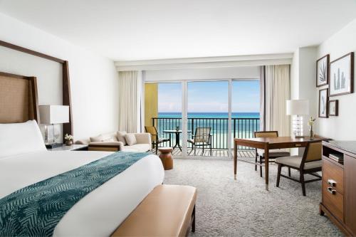 een hotelkamer met een bed en uitzicht op de oceaan bij The Ritz-Carlton, Aruba in Palm-Eagle Beach