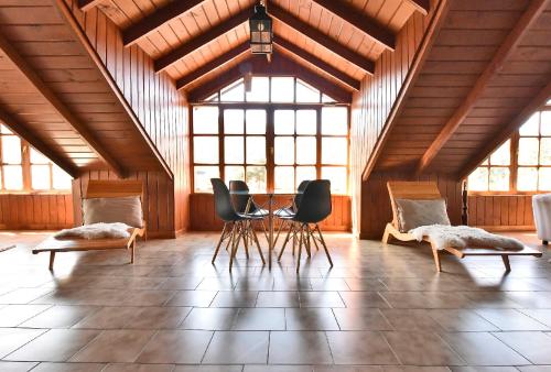 a room with chairs and a table in a building at Hotel Caupolican by Visionnaire in San Martín de los Andes