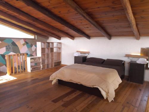 een slaapkamer met een bed in een kamer met houten vloeren bij CASA CIELO in Villa Berna