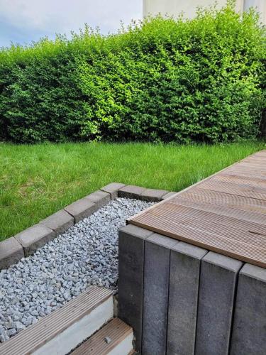 a garden with a wooden walkway and some grass at Püttlingen Appartement in Püttlingen