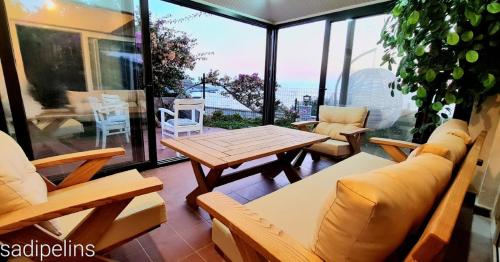 a screened in porch with a table and chairs at Denize sıfır benzersiz villa in Kusadası