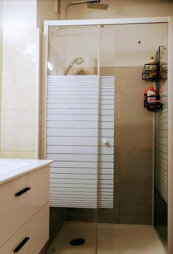 une douche avec une porte vitrée dans une salle de bain dans l'établissement Appartement équipé, Roquebrune Menton plage mer ., à Roquebrune-Cap-Martin