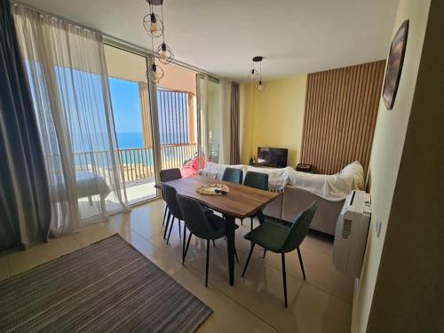 a living room with a table and a living room with a couch at Palase Jacuzzi apartment 157-D GC in Llogara
