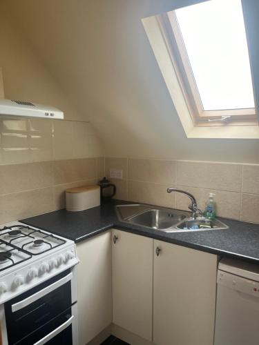 a kitchen with a stove and a sink and a window at Racecourse Lodge Apartment in Clifden