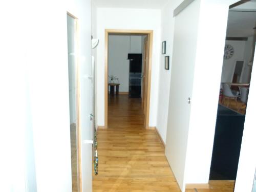 a hallway with white walls and a wooden floor at FeWo Annabell in Sankt Wendel