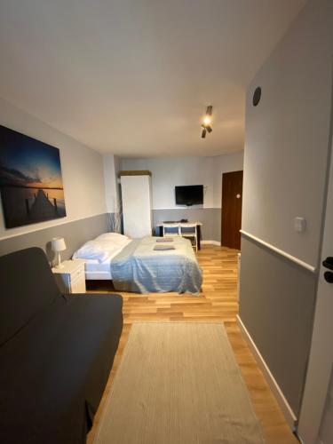 a bedroom with a bed and a couch in a room at Hacienda in Sopot