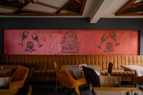 a restaurant with tables and chairs and a red wall at Apartments BRAVO in Ohrid