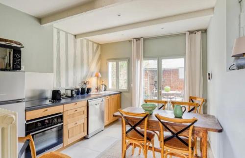 une cuisine avec une table et des chaises dans une cuisine dans l'établissement Maison de charme Beaumont, proche Deauville, à Beaumont-en-Auge
