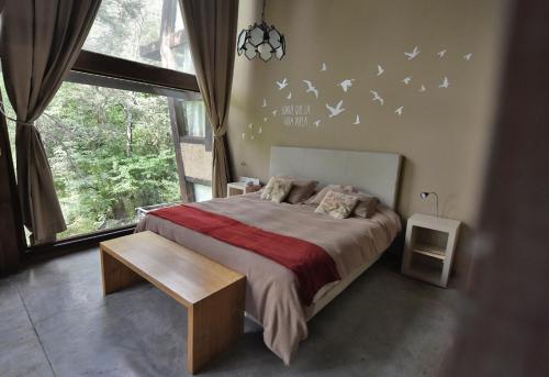 1 dormitorio con 1 cama con pájaros en la pared en Rosas Blancas Apart Hotel By Visionnaire en San Martín de los Andes
