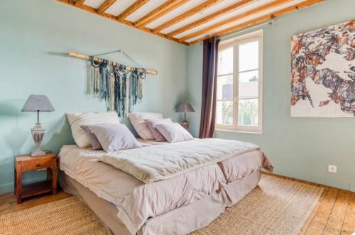 une chambre avec un grand lit et une fenêtre dans l'établissement Maison de charme Beaumont, proche Deauville, à Beaumont-en-Auge