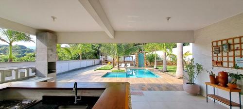 a kitchen with a view of a swimming pool at Casa com piscina e muita tranquilidade in Rio de Janeiro