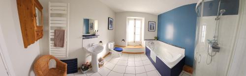 une salle de bain avec une baignoire, un lavabo et des toilettes dans l'établissement La petite Maison, à Argenton-Château