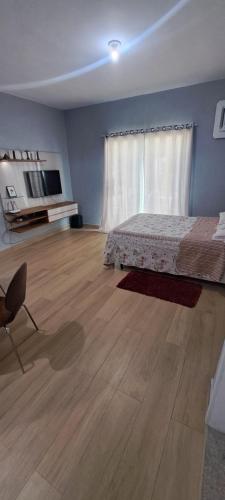 a bedroom with a bed and a wooden floor at Casa com piscina e muita tranquilidade in Rio de Janeiro
