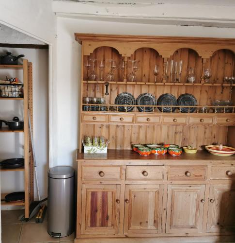 d'une armoire en bois avec des assiettes et de la vaisselle. dans l'établissement La petite Maison, à Argenton-Château